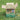 Bunny Bistro Premium Timothy Hay 1st Cut 4kg Box open on grass with white flowers, front view.
